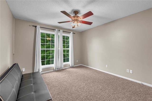unfurnished living room featuring ceiling fan, carpet floors, a textured ceiling, and baseboards