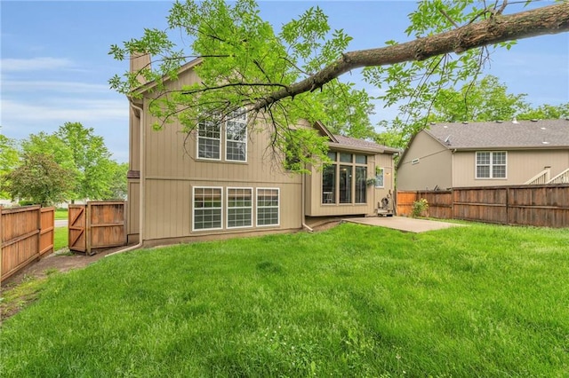 rear view of house featuring a chimney, a patio area, and a gate