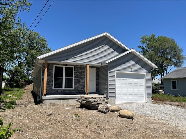 449 E Market St, Warrensburg, MO 64093 - view of front of house featuring an attached garage, driveway, and stone siding