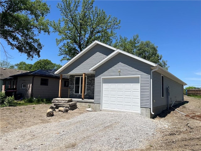 449 E Market St, Warrensburg, MO 64093 - ranch-style house with an attached garage, driveway, and stone siding