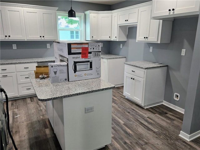 449 E Market St, Warrensburg, MO 64093 - kitchen with dark wood-style flooring, white cabinets, light stone counters, and hanging light fixtures