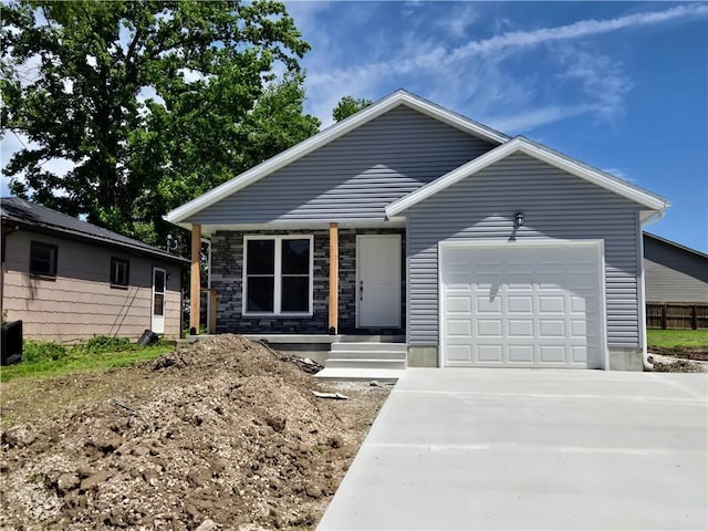 449 E Market St, Warrensburg, MO 64093 - view of front of property with concrete driveway, an attached garage, and stone siding