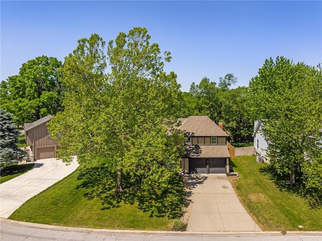 view of front of house featuring driveway, board and batten siding, a front yard, and a garage