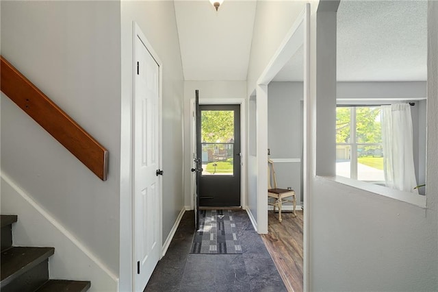 doorway to outside with healthy amount of natural light, stairs, and baseboards