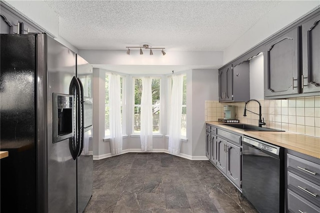 kitchen with black refrigerator with ice dispenser, dishwasher, gray cabinets, a sink, and a textured ceiling