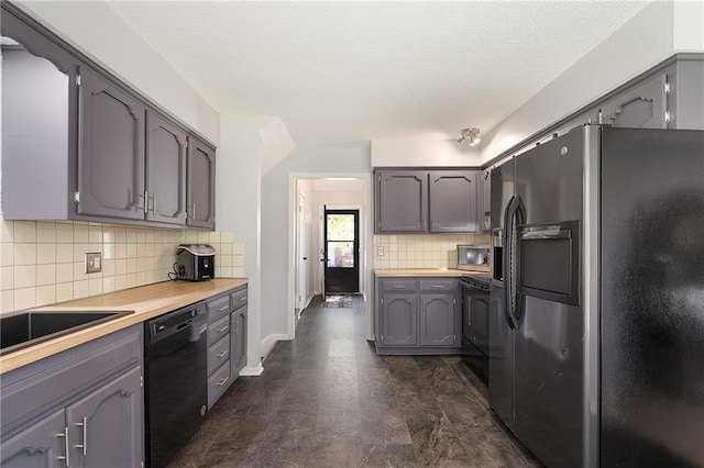 kitchen featuring black appliances, tasteful backsplash, light countertops, and baseboards