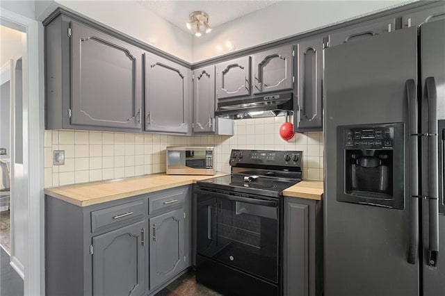 kitchen with stainless steel appliances, under cabinet range hood, wood counters, and gray cabinets