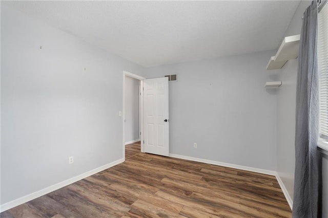 unfurnished room with wood finished floors and baseboards