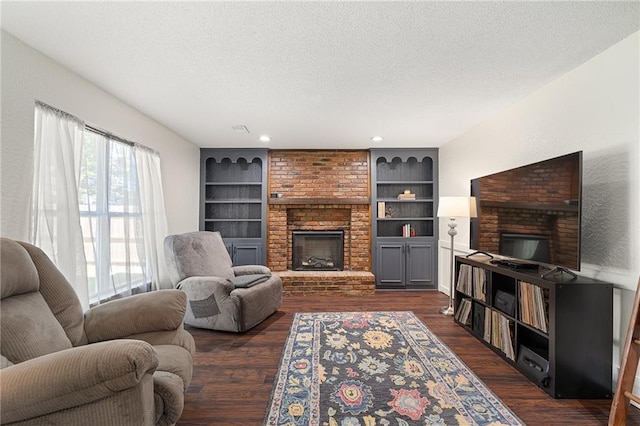 living area with a fireplace, a textured ceiling, dark wood-type flooring, built in features, and recessed lighting