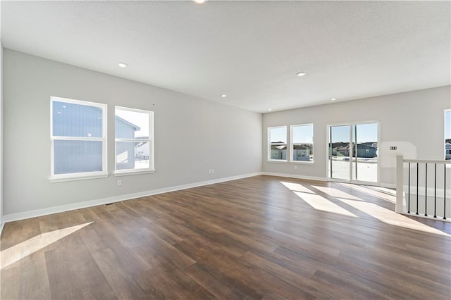 501 Woodview Dr, Raymore, MO 64083 - unfurnished living room featuring wood finished floors, baseboards, and recessed lighting