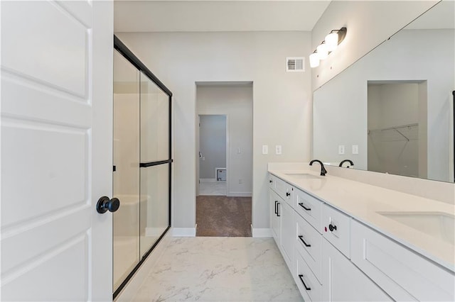 501 Woodview Dr, Raymore, MO 64083 - full bath with marble look tile flooring, a stall shower, baseboards, double vanity, and a walk in closet