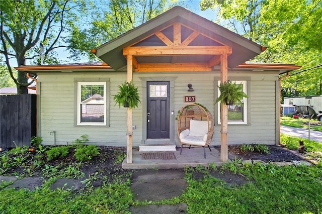 view of front facade with a porch and fence