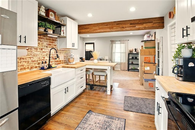 kitchen featuring wooden counters, black appliances, a sink, open shelves, and recessed lighting