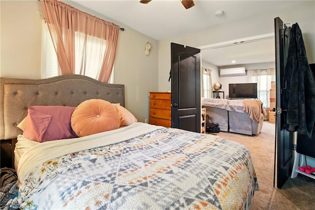 carpeted bedroom with a wall unit AC and ceiling fan