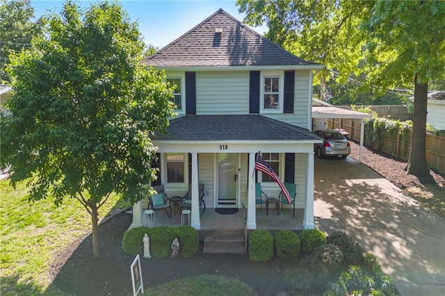 view of front of house featuring driveway, roof with shingles, a porch, fence, and an attached carport