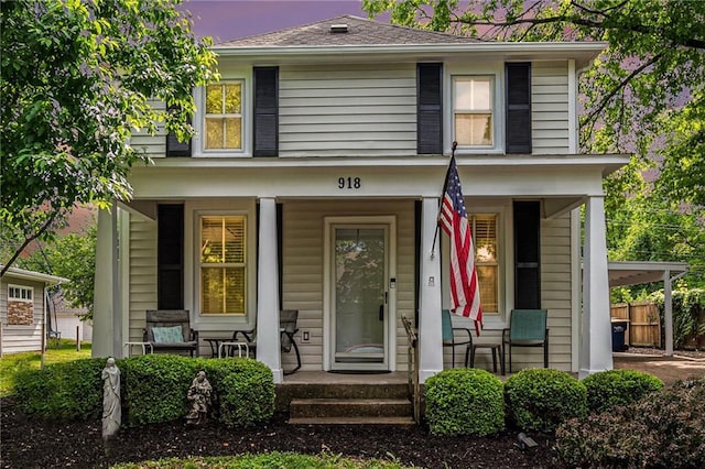 view of front facade with a porch and fence