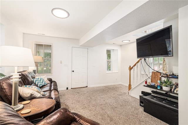 carpeted living room with stairway, plenty of natural light, and baseboards