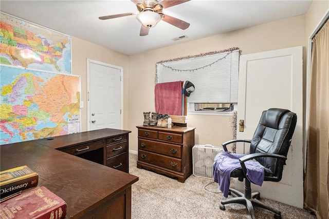 office space with light carpet and a ceiling fan