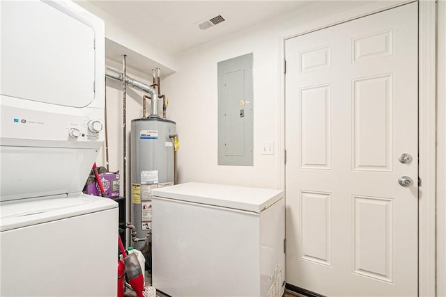washroom with stacked washer / drying machine, water heater, and electric panel