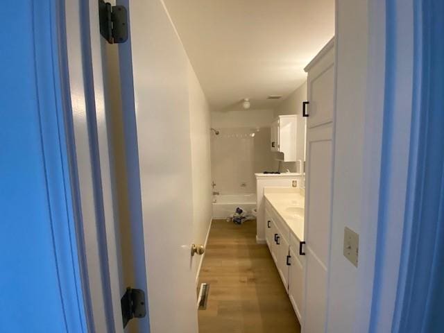 bathroom featuring vanity, wood finished floors, and shower / tub combination
