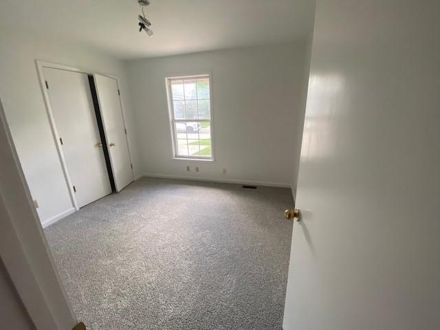 unfurnished bedroom featuring carpet and baseboards