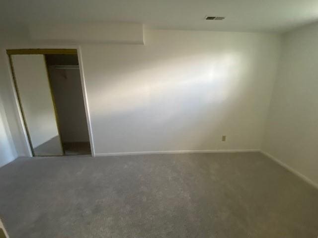 unfurnished bedroom featuring carpet floors, baseboards, and a closet
