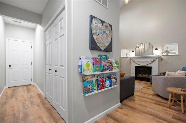 playroom featuring wood finished floors, a fireplace, and baseboards