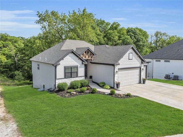 18235 NW 127th St, Platte City, MO 64079 - view of front of house with stone siding, an attached garage, concrete driveway, a front yard, and central AC unit