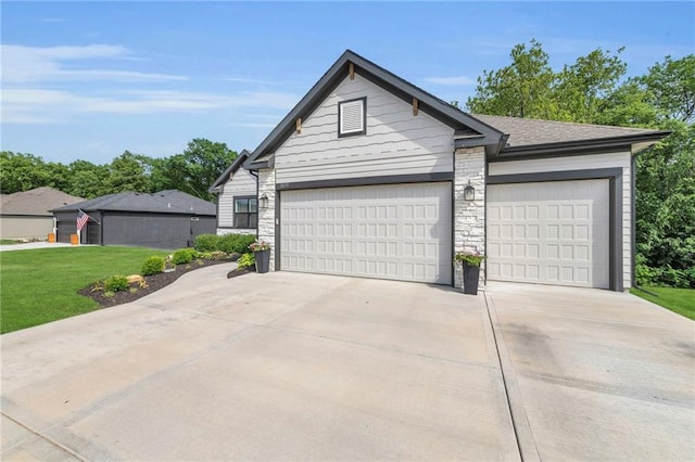 18235 NW 127th St, Platte City, MO 64079 - view of front of house featuring stone siding, concrete driveway, a front yard, and a garage