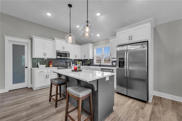 18235 NW 127th St, Platte City, MO 64079 - kitchen with appliances with stainless steel finishes, white cabinetry, light wood-style floors, lofted ceiling, and recessed lighting