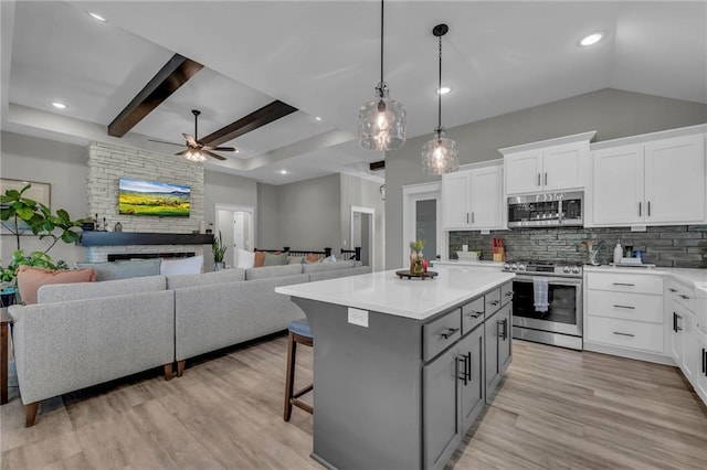 18235 NW 127th St, Platte City, MO 64079 - kitchen featuring appliances with stainless steel finishes, gray cabinetry, a ceiling fan, decorative backsplash, and a center island
