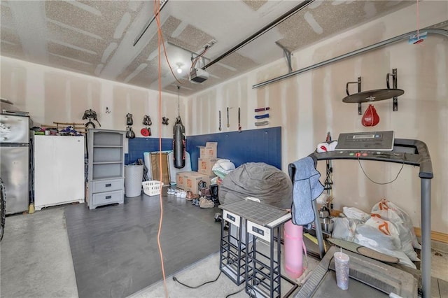 18235 NW 127th St, Platte City, MO 64079 - garage with freestanding refrigerator, a garage door opener, and white refrigerator