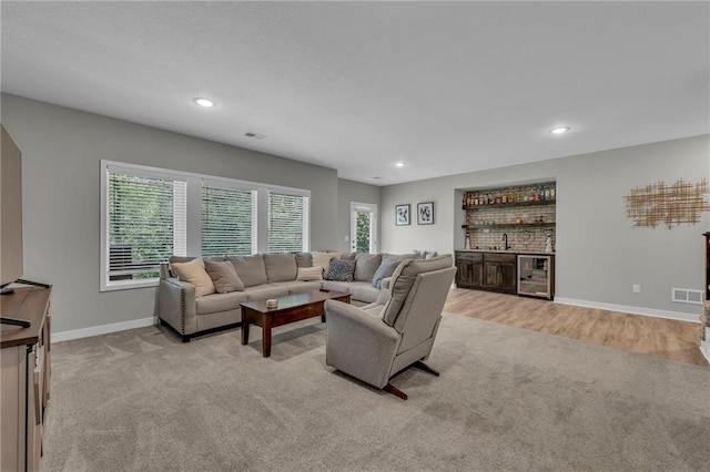 18235 NW 127th St, Platte City, MO 64079 - living room with light carpet, bar, wine cooler, baseboards, and recessed lighting
