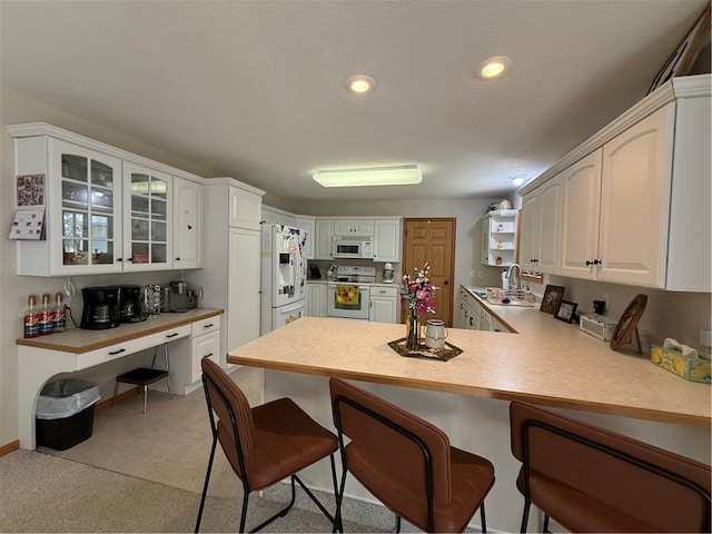 727 Serenity Loop, Maryville, MO 64468 - kitchen featuring white appliances, a peninsula, a breakfast bar, a sink, and recessed lighting