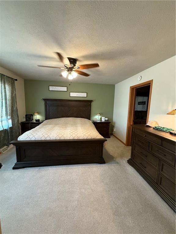 727 Serenity Loop, Maryville, MO 64468 - bedroom with light carpet, a textured ceiling, and ceiling fan