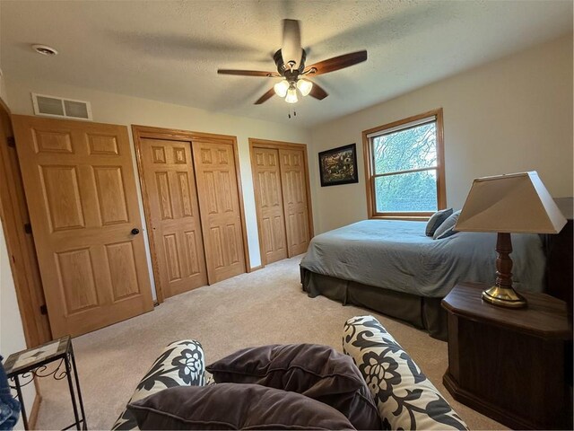 727 Serenity Loop, Maryville, MO 64468 - bedroom with carpet, multiple closets, a ceiling fan, and a textured ceiling
