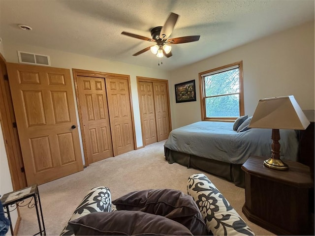 727 Serenity Loop, Maryville, MO 64468 - bedroom featuring carpet flooring, two closets, a textured ceiling, and a ceiling fan