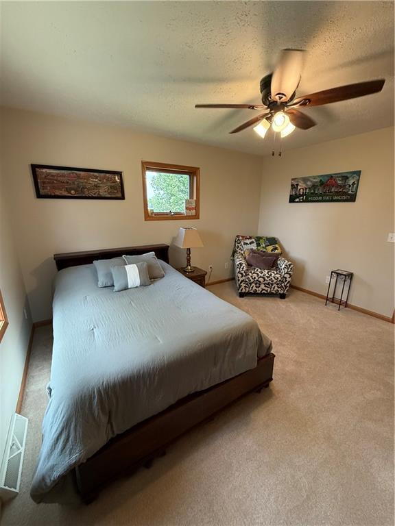 727 Serenity Loop, Maryville, MO 64468 - carpeted bedroom with ceiling fan, baseboards, and a textured ceiling