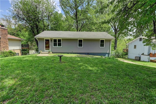 view of front of home with a front yard and central AC