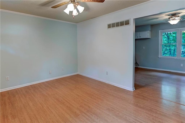 spare room featuring a ceiling fan, light wood-style flooring, crown molding, and baseboards