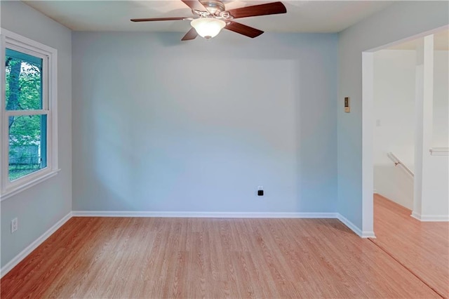 unfurnished room with light wood-style flooring, baseboards, and a ceiling fan