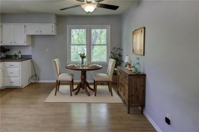 dining room with ceiling fan, light wood-type flooring, and baseboards
