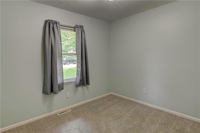 carpeted empty room featuring baseboards
