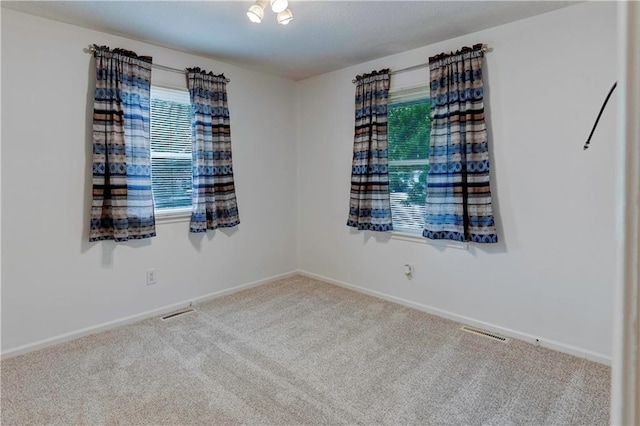 carpeted empty room featuring baseboards