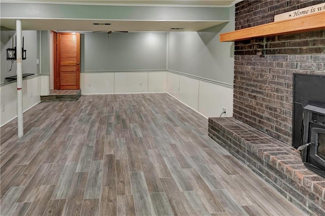 finished basement with wood finished floors and a wood stove