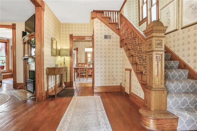 stairs featuring wallpapered walls, hardwood / wood-style flooring, and baseboards
