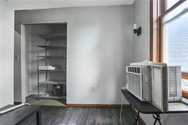 detailed view of baseboards, wood finished floors, and cooling unit