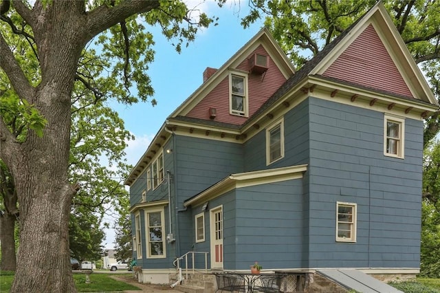 back of house featuring a chimney