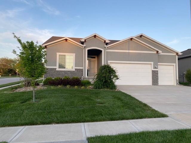 10617 N Fisk Ave, Kansas City, MO 64154 - ranch-style home with an attached garage, stucco siding, stone siding, a front yard, and driveway