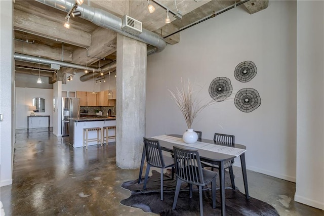 dining space with finished concrete flooring and baseboards